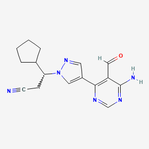 Chemical structure of (R)-3-(4-(6-Amino-5-formylpyrimidin-4-yl)-1H-pyrazol-1-yl)-3-cyclopentylpropanenitrile